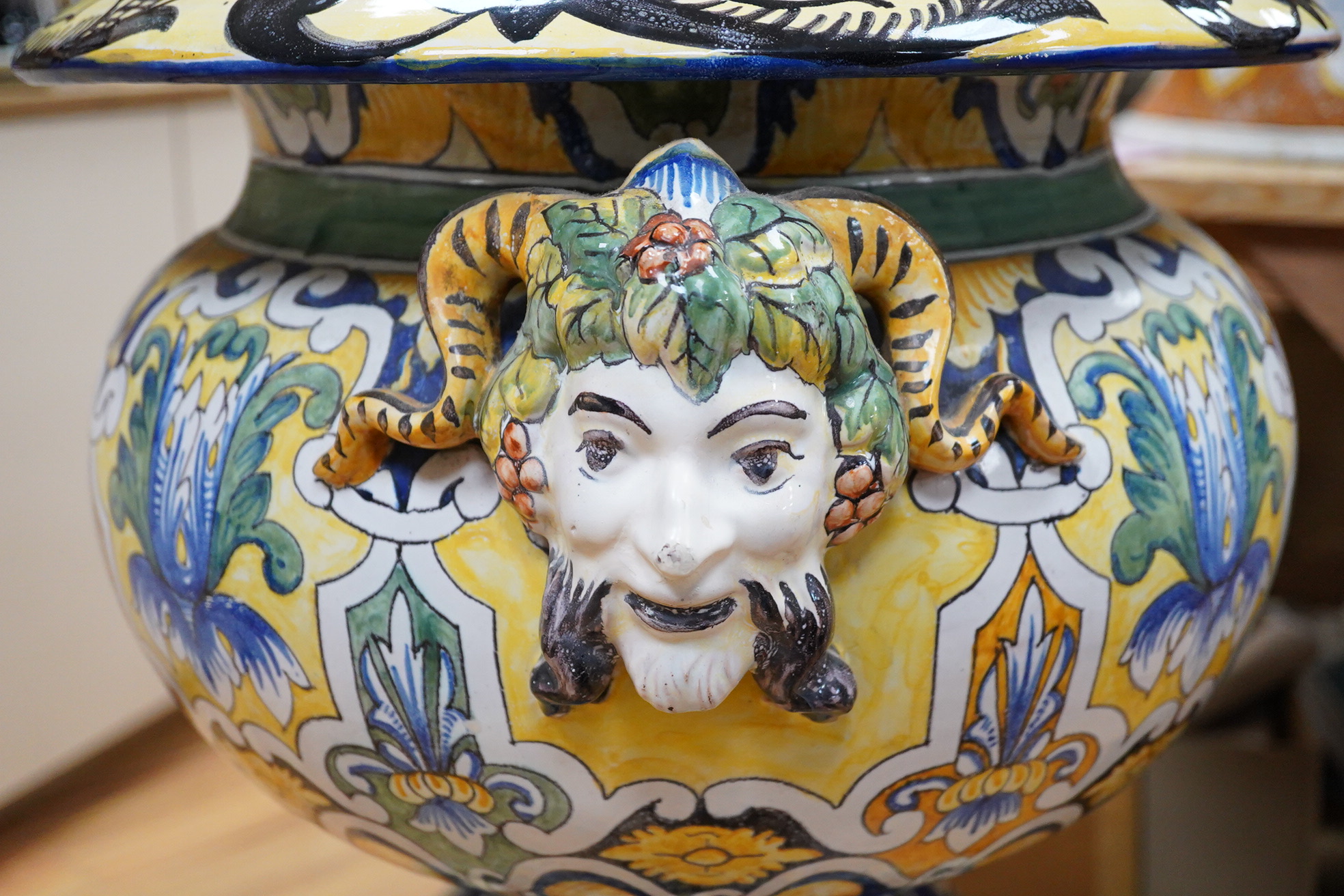 A tall decorative French faience pottery jardiniere with Bacchus mask mounts and a similar associated stand